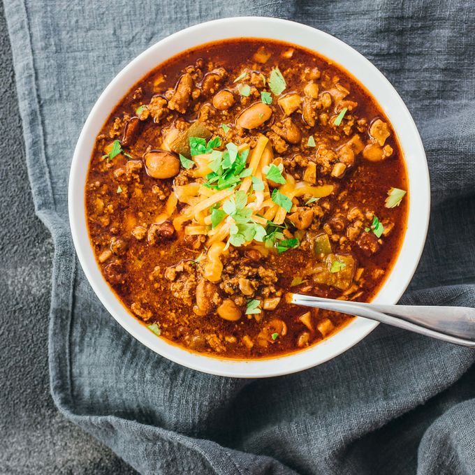 Low carb chili made in a pressure cooker instant pot and served in a white bowl topped with cheddar cheese