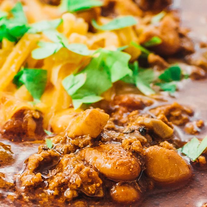 Close up view of low carb instant pot chili with canned beans, ground beef, cheddar cheese, and cilantro