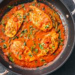 tomato chicken simmering in a garlic basil sauce
