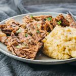 Instant Pot boneless leg of lamb served on a plate with mashed cauliflower