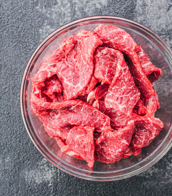 raw sliced chuck beef in glass bowl