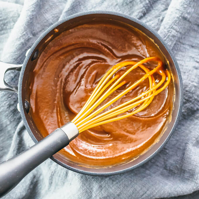 whisking peanut sauce in black pot