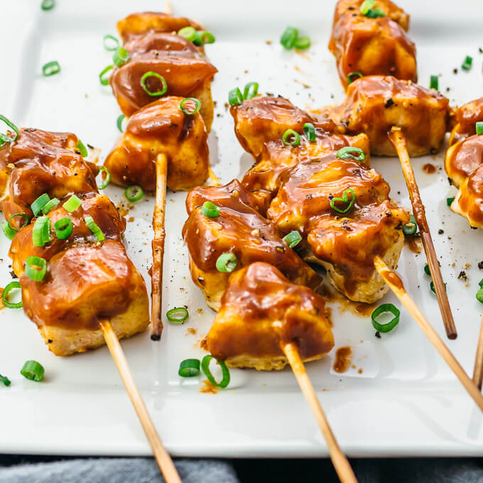 chicken satay skewers on white plate