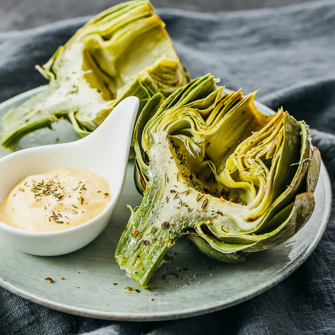 microwaved artichokes served on plate with dip