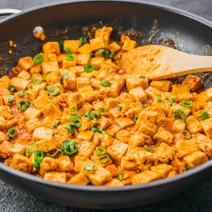 cooking tofu stir fry on black skillet