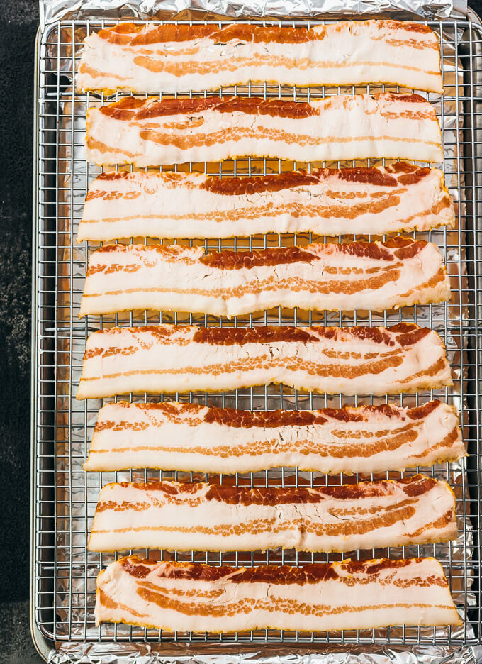 raw bacon slices on baking tray
