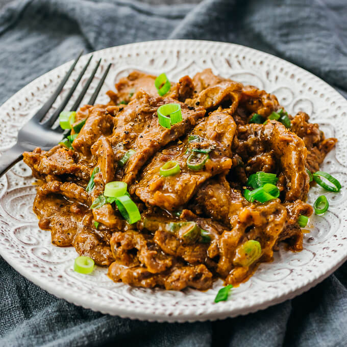 hunan beef and scallions on white plate