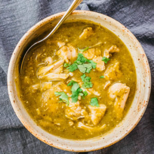 chili verde served in bowl with a spoon