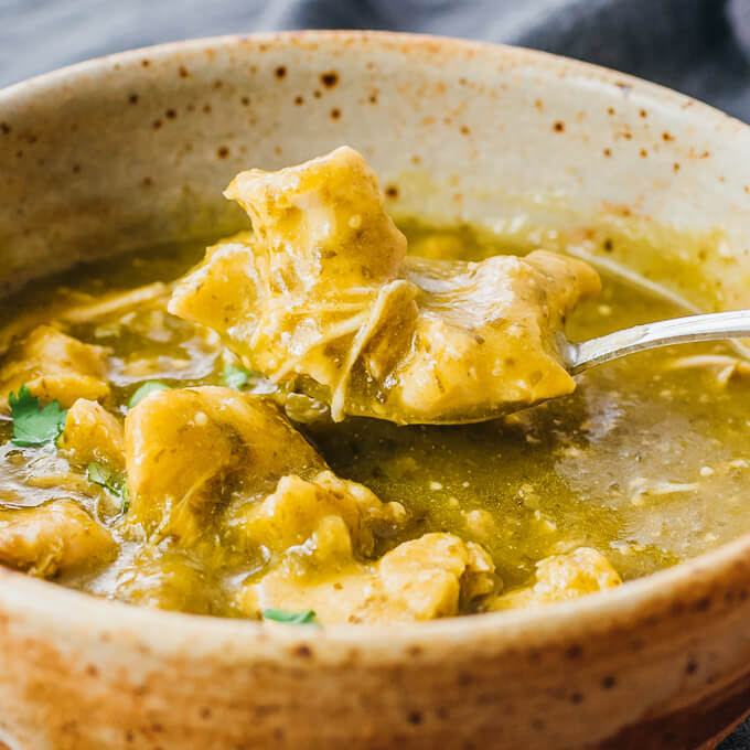 scooping up chili verde chicken with spoon