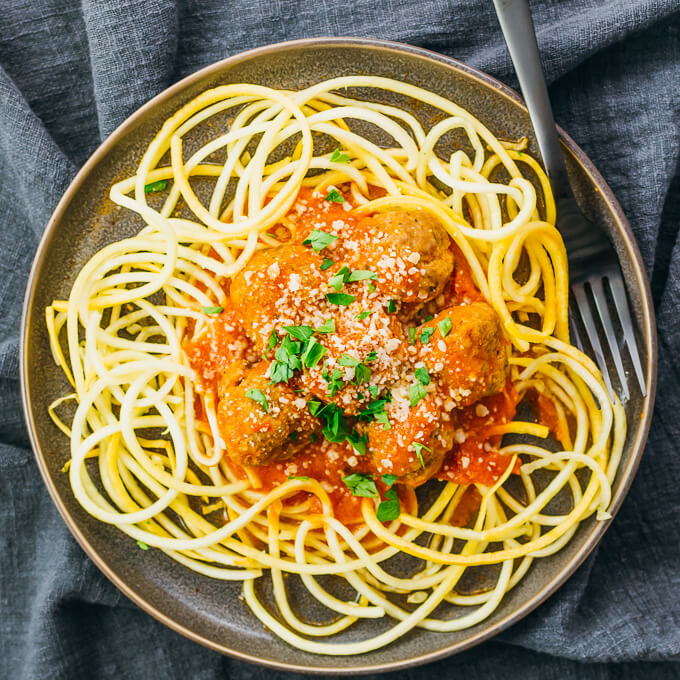 instant pot meatballs over spiralized squash and topped with parsley and cheese