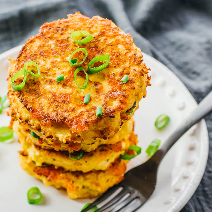 tall stack of fried cauliflower fritters on white plate