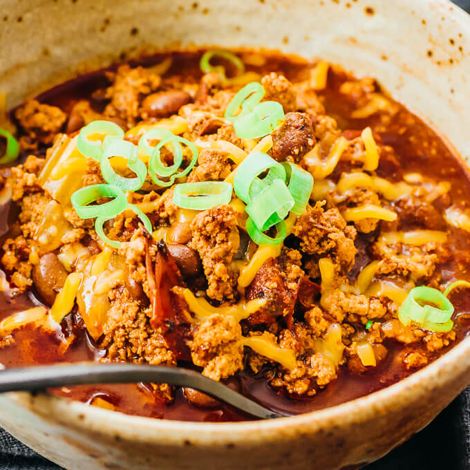 instant pot turkey chili topped with cheddar cheese and scallions