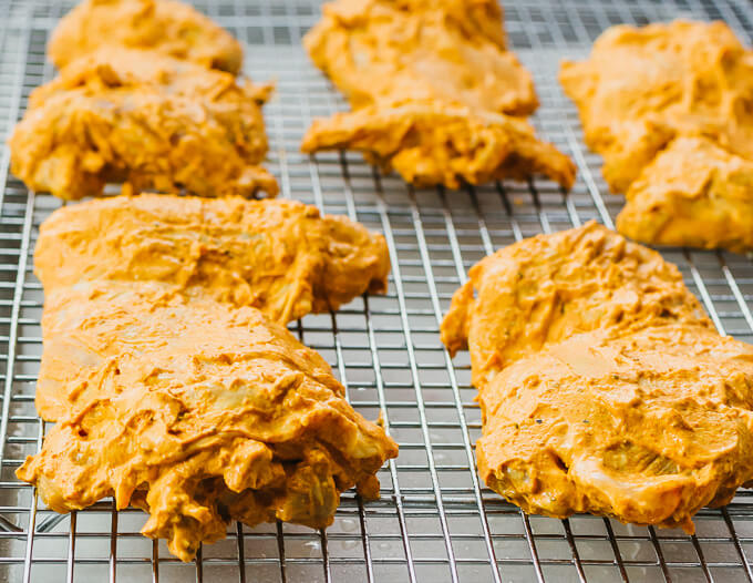 yogurt marinade covered chicken thighs on baking sheet