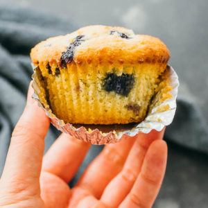 close up view of keto blueberry muffin with wrapper open