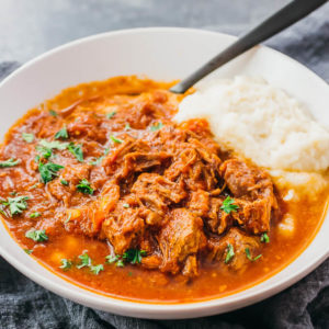 beef ragu served with cauliflower mash in white bowl