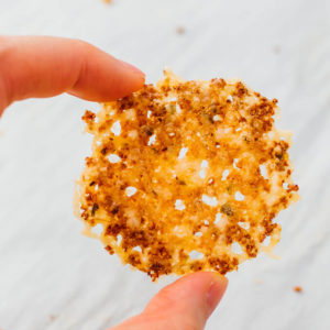 holding up a parmesan crisp using fingers