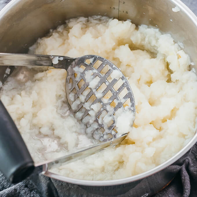 mashing boiled turnips in pot