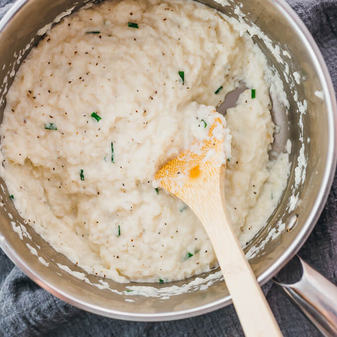 stirring mashed turnips in pot