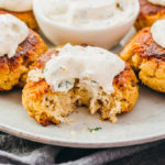 close up view of salmon patties with sour cream dip