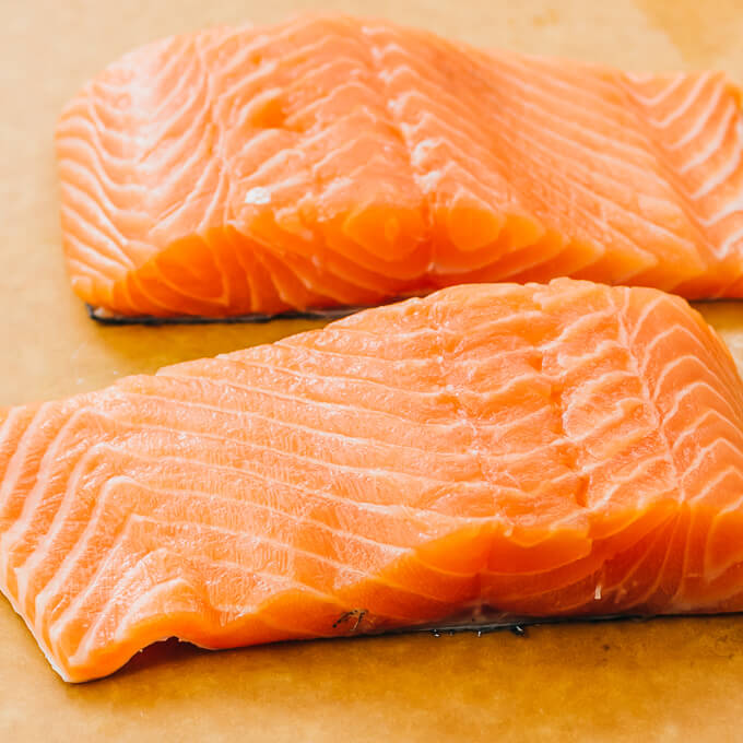 two raw center cut salmon fillets on a cutting board