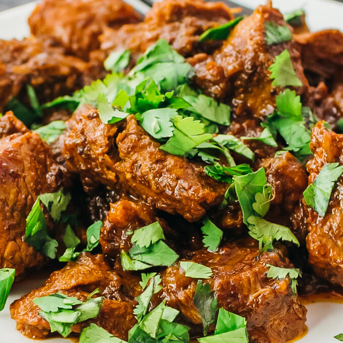 fresh cilantro leaves garnishing roasted pork shoulder