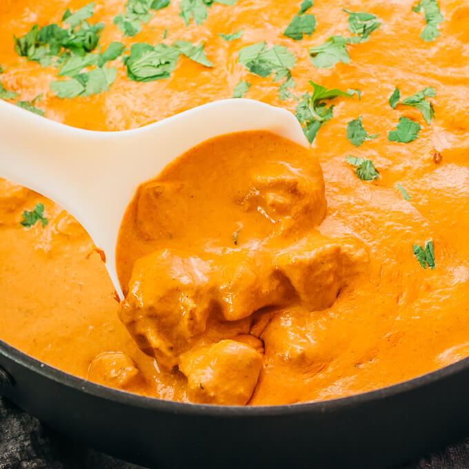 stirring chicken tikka masala in pan