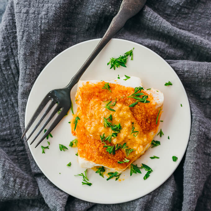 parmesan baked cod served on white plate