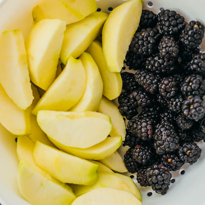 peeled apple wedges and blackberries in bowl