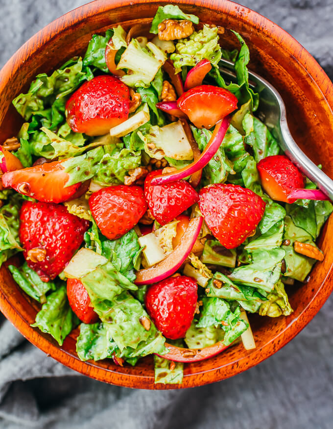 overhead view of summer strawberry salad in wooden bowl