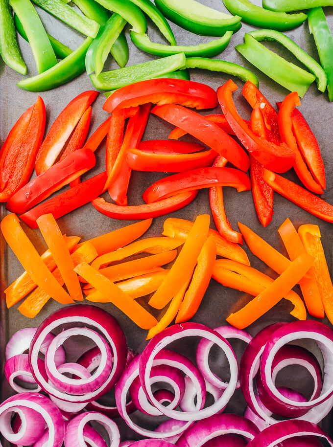 sliced bell peppers and onion rings on sheet pan