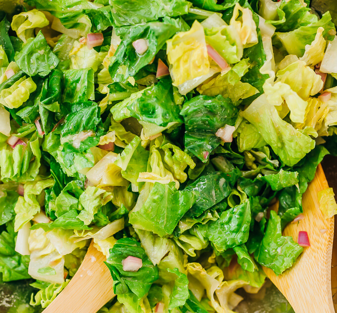 tossing romaine lettuce with red wine vinaigrette