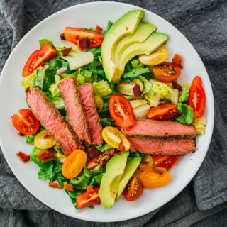 steak salad with tomatoes and avocado over lettuce