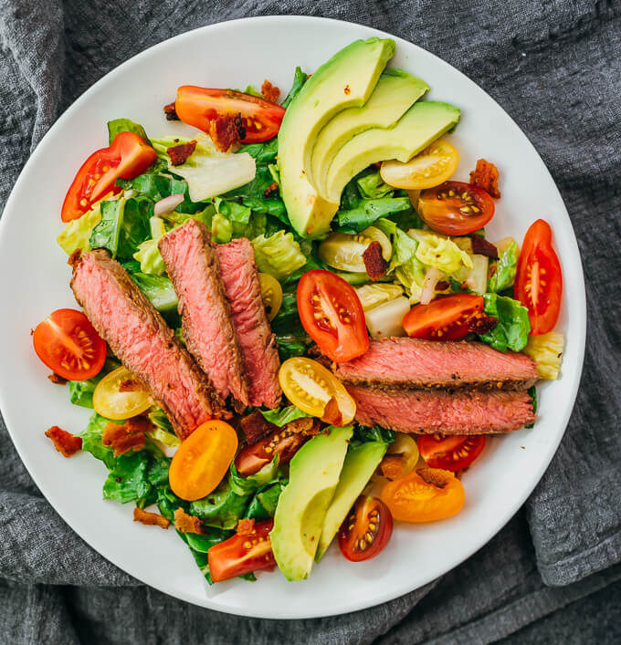 steak salad with tomatoes and avocado over lettuce