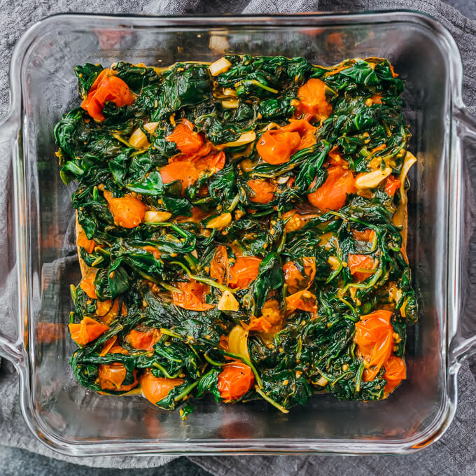 cooked spinach and tomatoes in baking dish