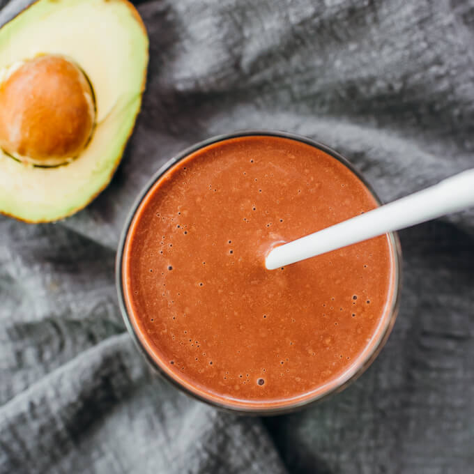 overhead view of chocolate avocado smoothie with straw