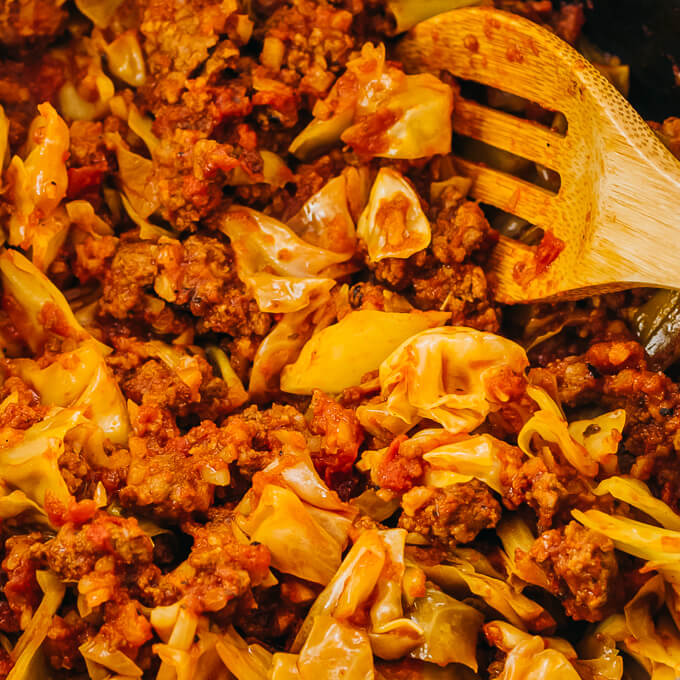 stirring ground beef with cabbage and tomatoes