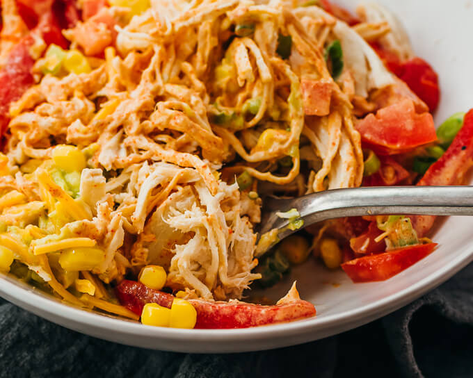 stirring chicken burrito bowl with fork