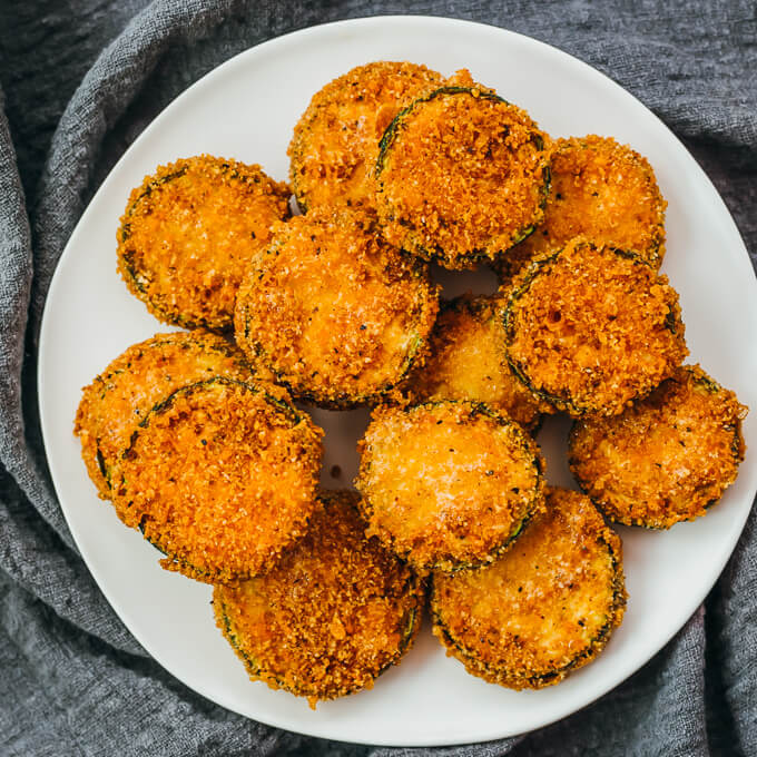 fried zucchini slices served on white plate