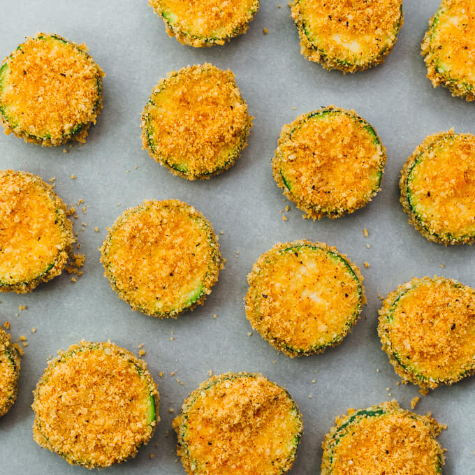 breaded zucchini slices on parchment paper