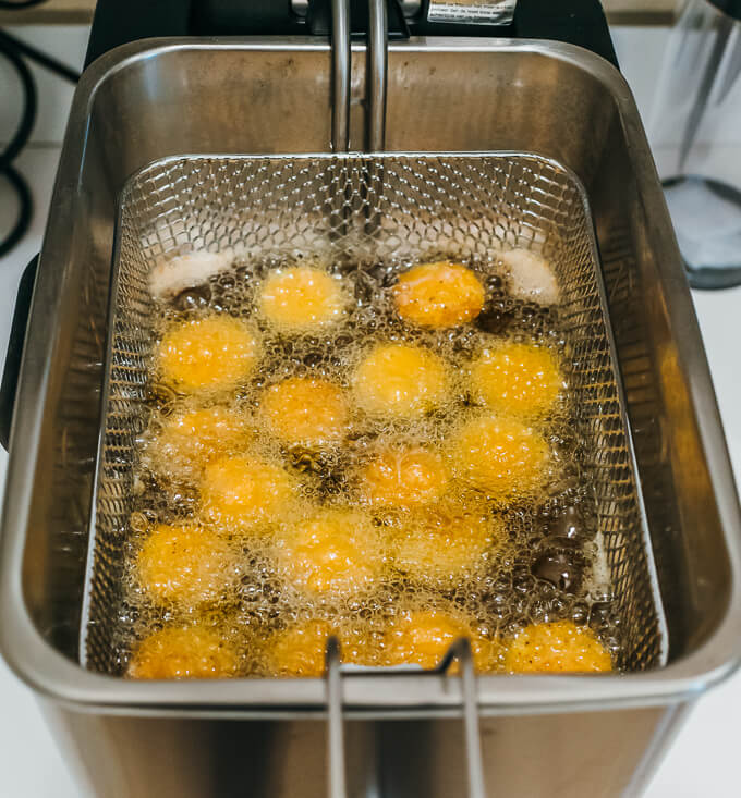 zucchini slices frying in deep fryer