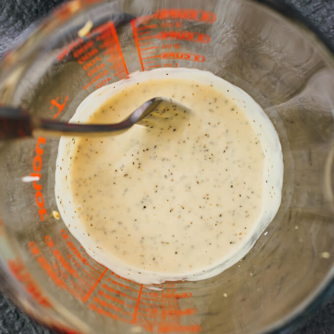stirred keto coleslaw dressing in measuring glass