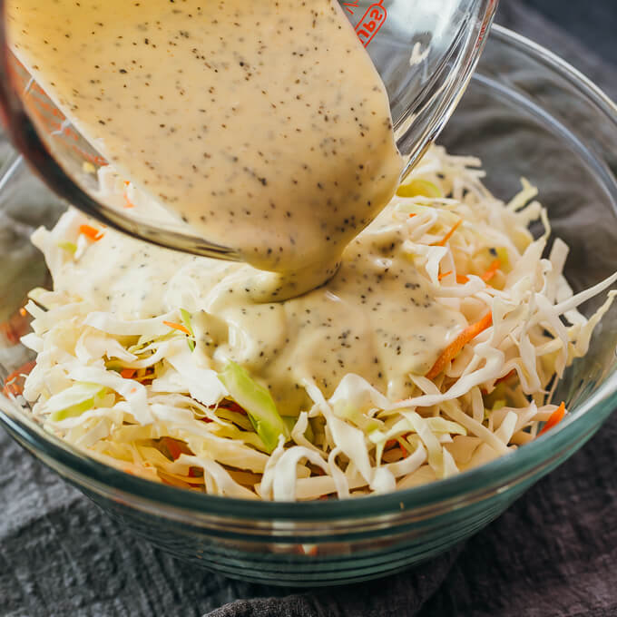 pouring dressing over coleslaw mix