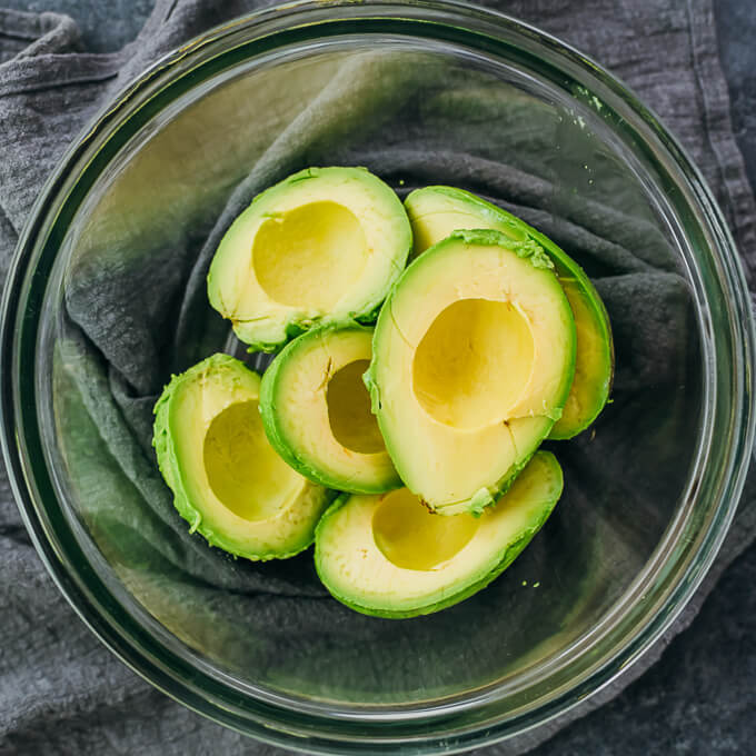 avocado halves in glass bowl