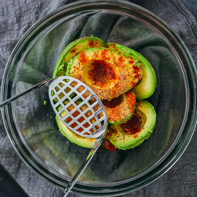 seasonings sprinkled over avocado halves