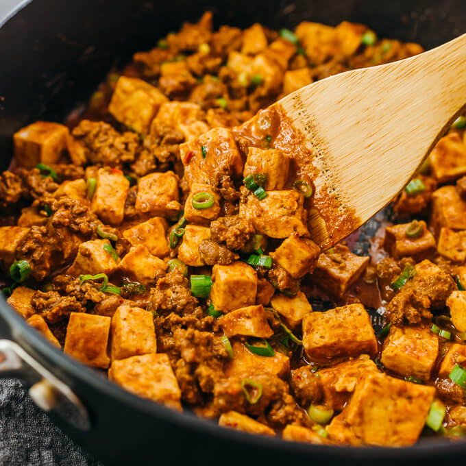 close up view of stirring mapo tofu in skillet