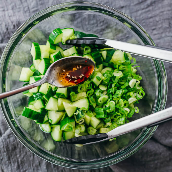 drizzling sauce over cucumbers and scallions