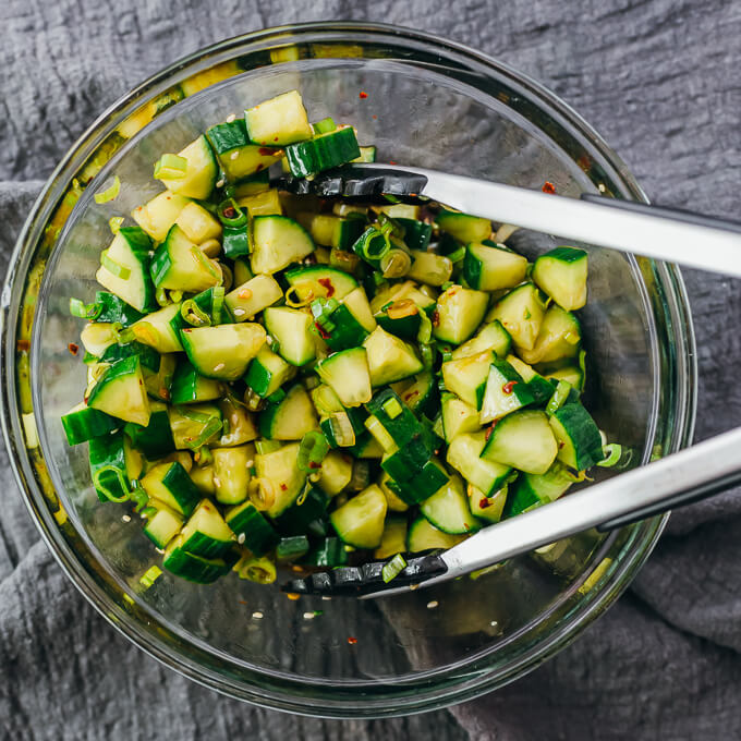 stirring cucumbers with asian dressing