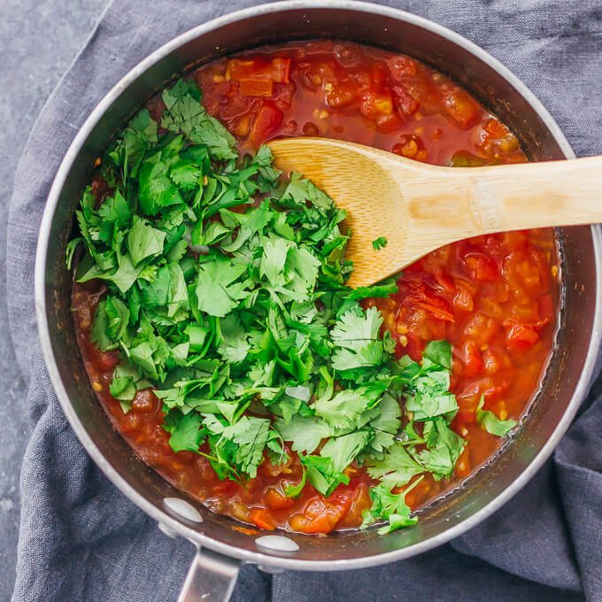 adding cilantro to saucepan