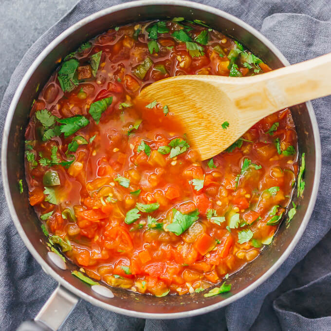 stirring cilantro with tomatoes