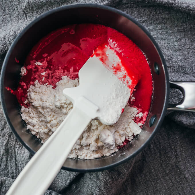 stirring raspberry puree with sweetener